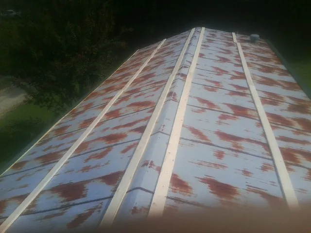Rusted metal roof panels with new wood purlins before replacement — Storm Damage Roof Repair in Madisonville by Roofing Brothers